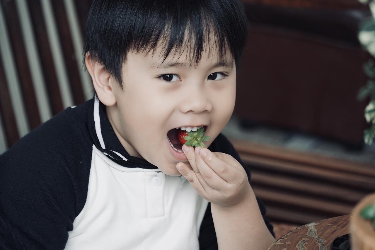 chłopiec je truskawkę